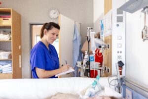 Pflegerin am Bett eines Patienten